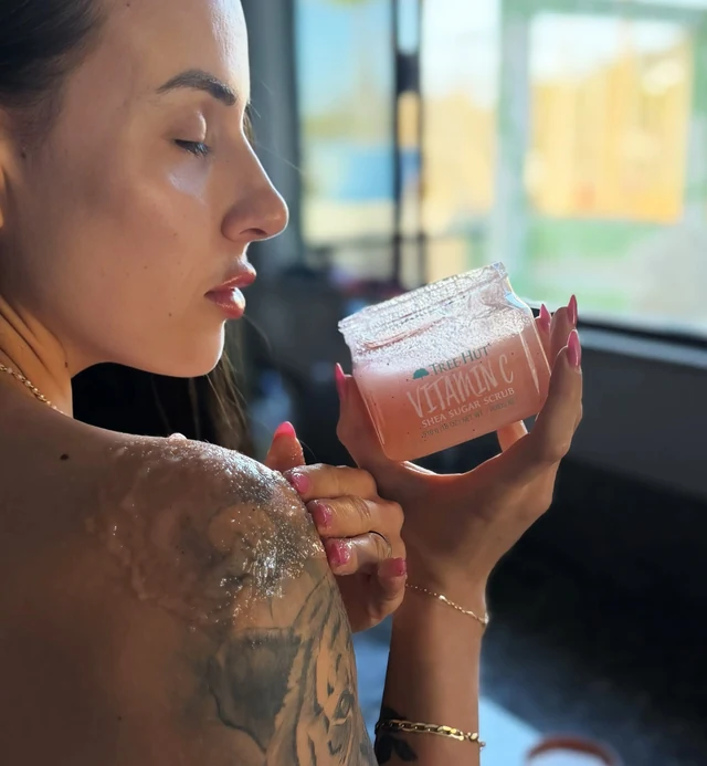 Close de Aline sentindo a fragrância de um produto em um ambiente iluminado